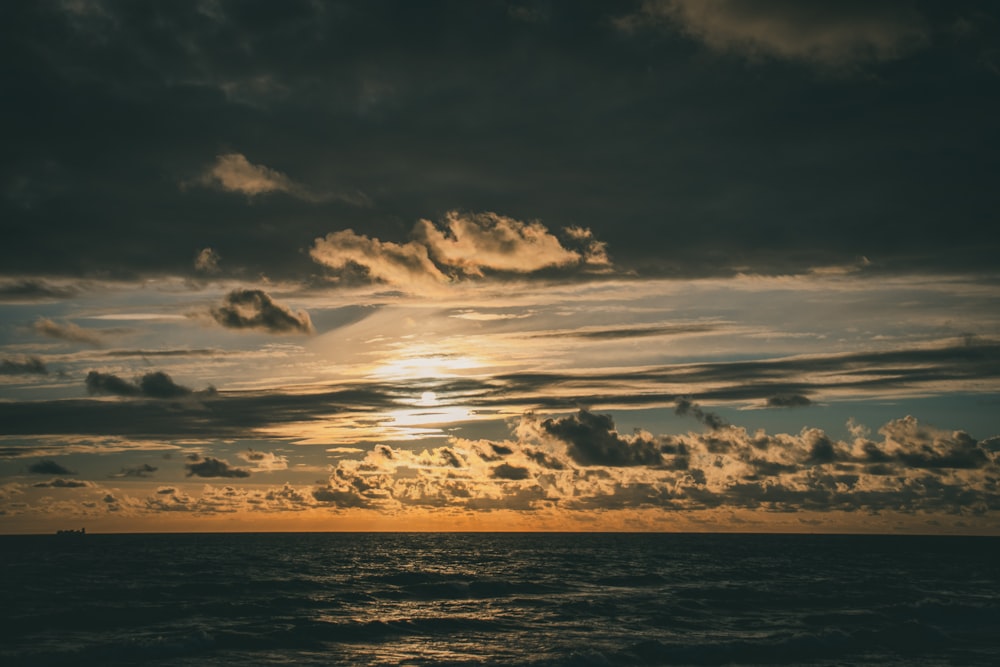 a body of water with clouds above it