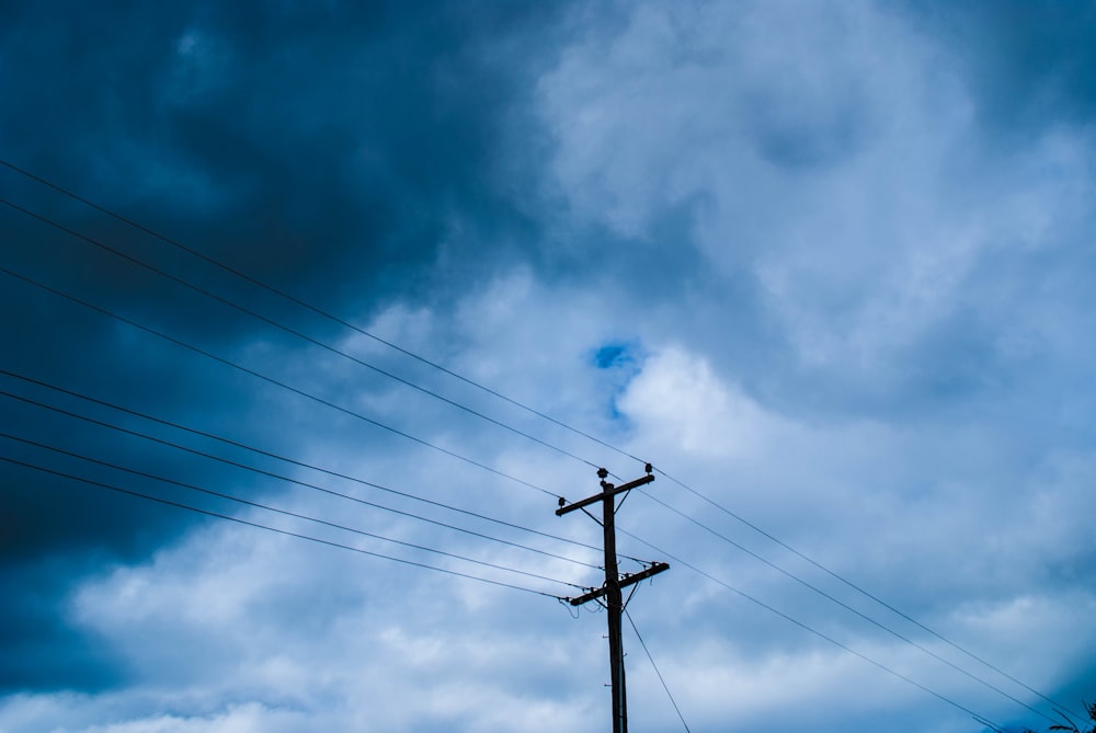 a close up of a light post in front of a cloudy blue sky