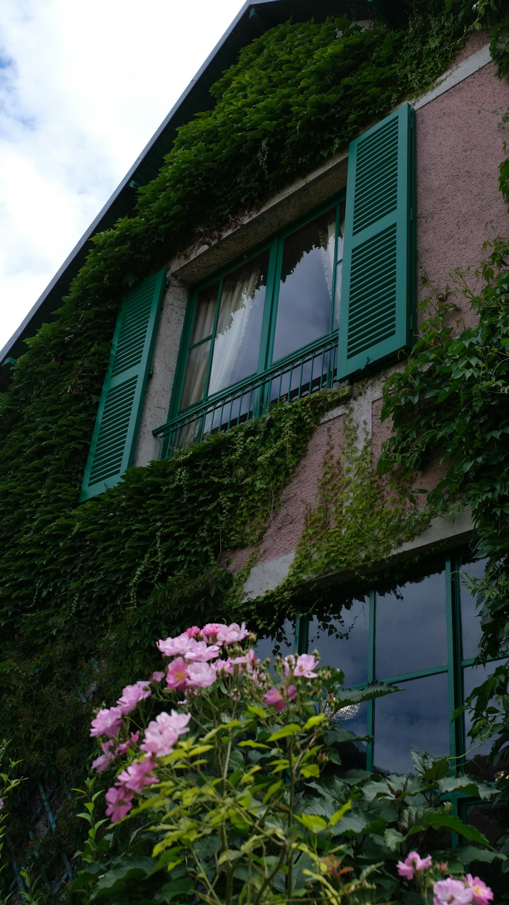 a green house with a balcony