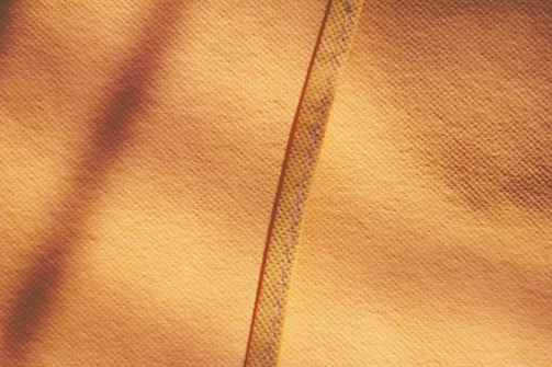 Close-up of textured orange decorative wallpaper applied to wall