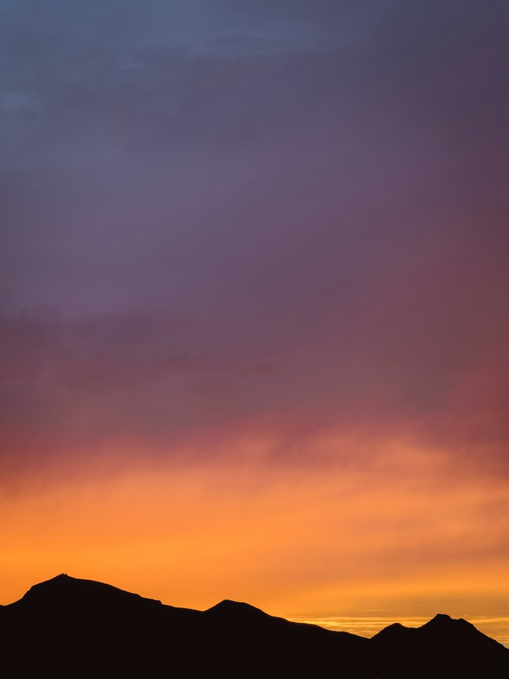 un coucher de soleil sur une chaîne de montagnes