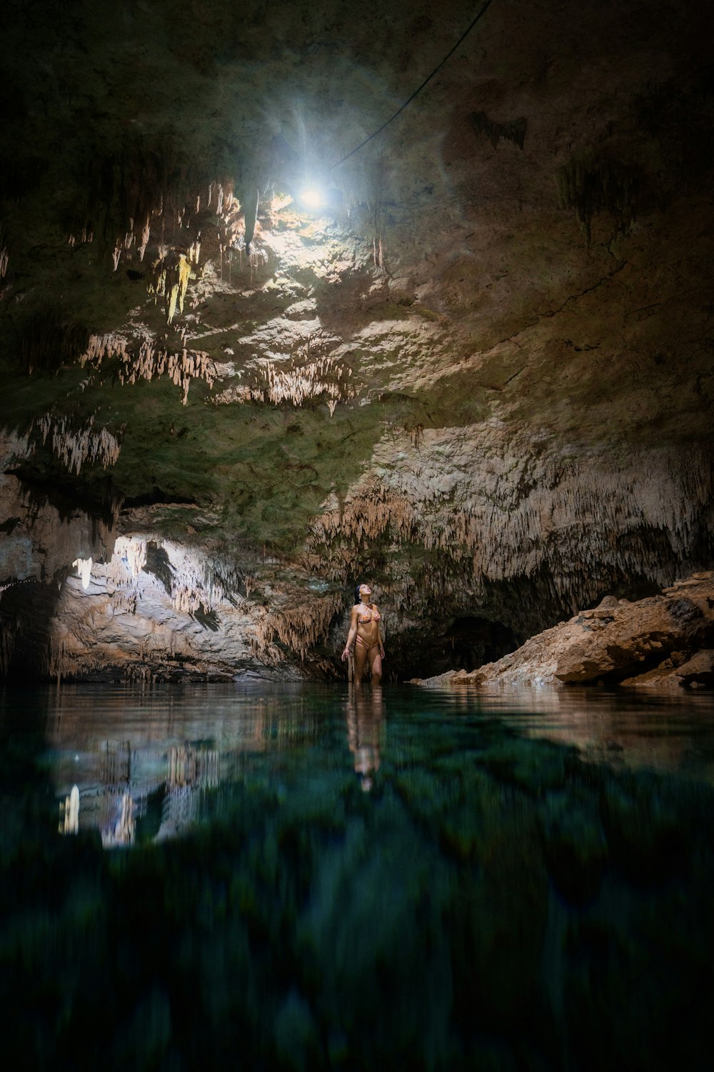 a person standing on a rock in a river at night