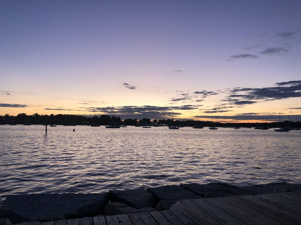 a body of water with rocks and a land in the distance