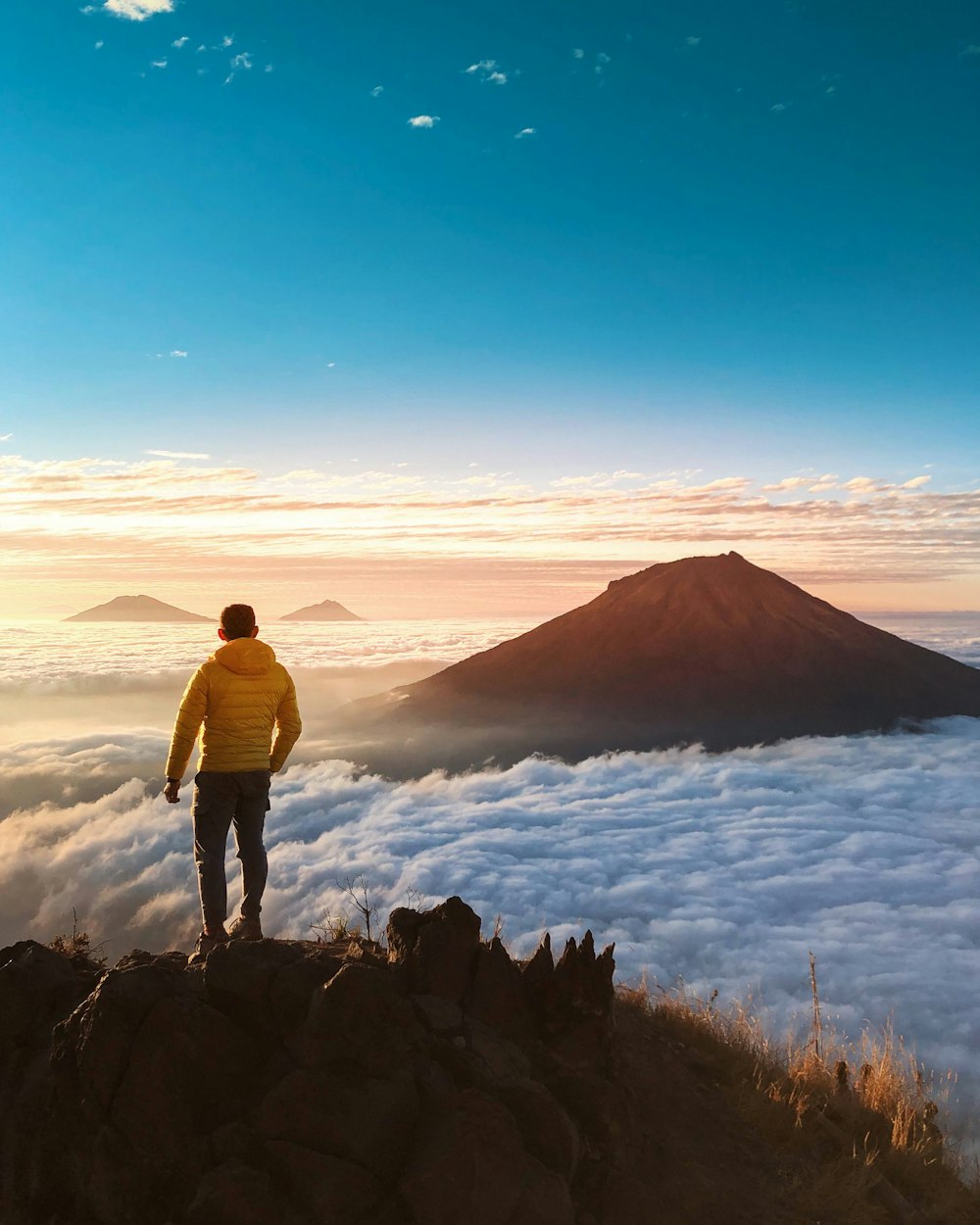 a person standing on a cliff looking at a large body of water