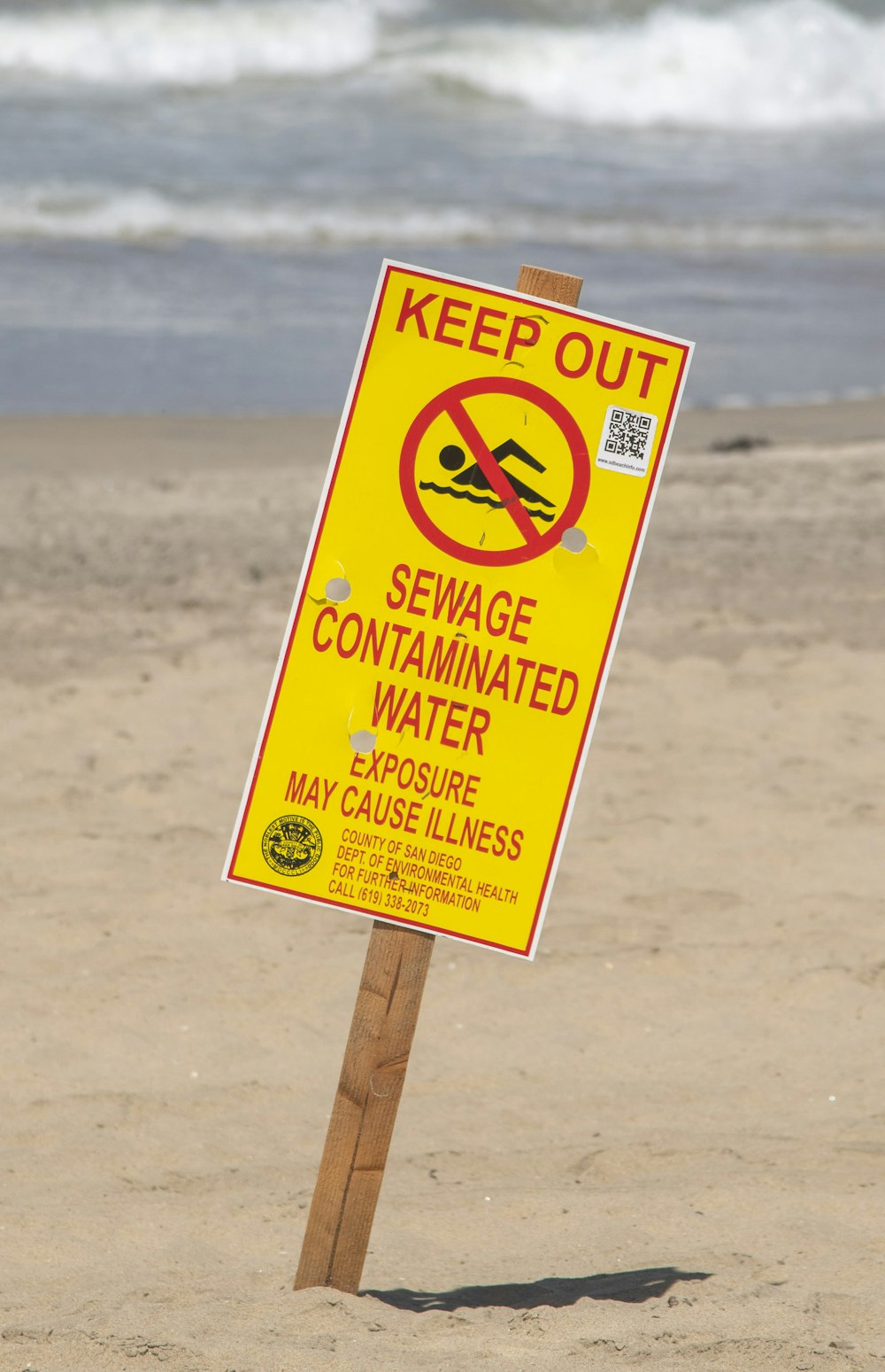 a yellow sign on a beach
