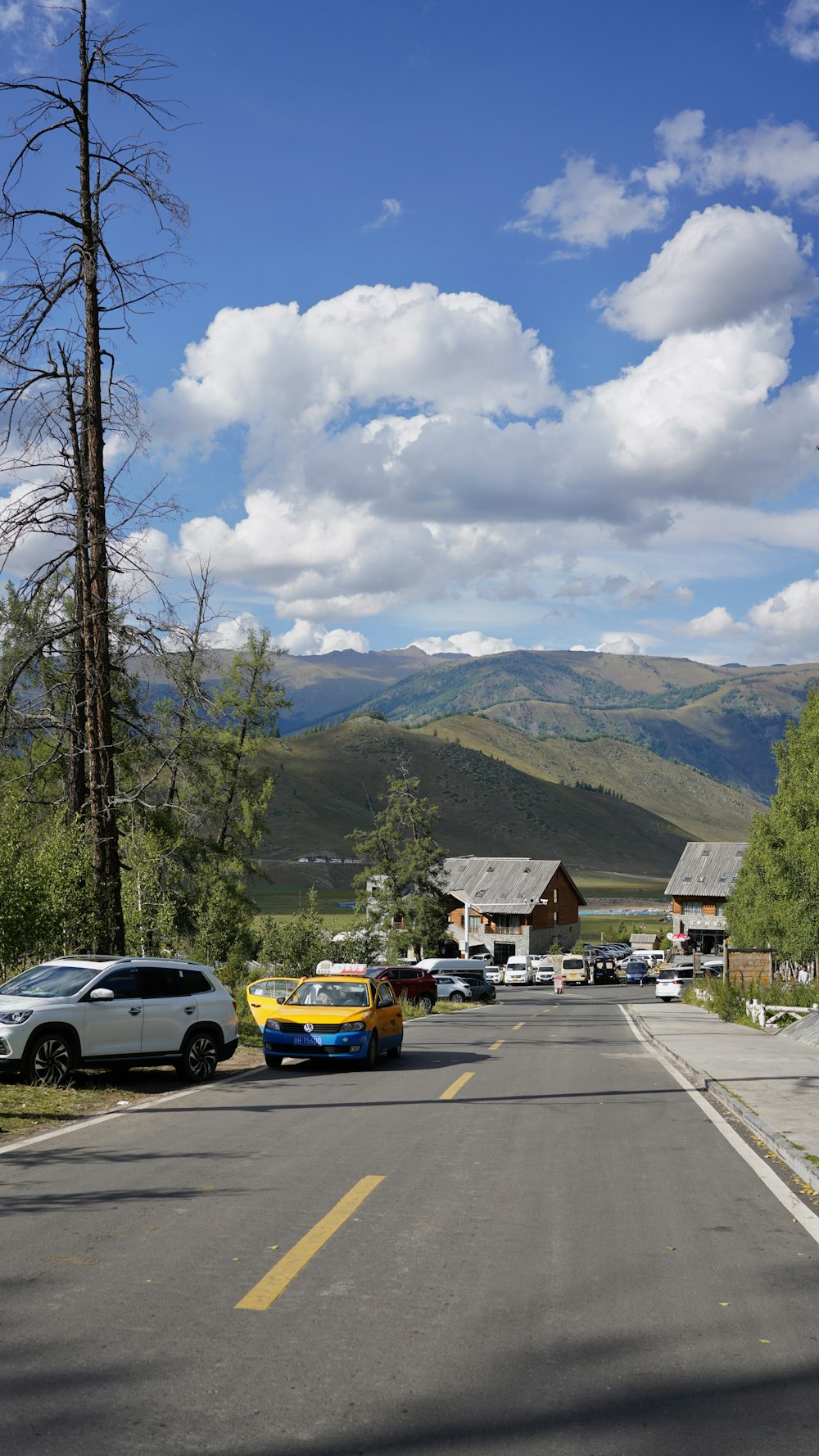 a street with cars and houses on the side