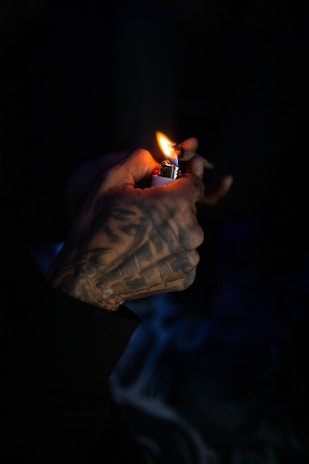 Hand holding a custom engraved lighter with delicate line work.