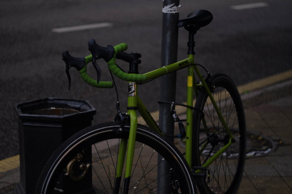 a green bicycle parked on a sidewalk