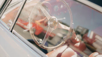 A restored leather steering wheel shining under soft light inside a car.
