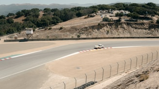 A vintage racing car roaring down a dusty dirt track