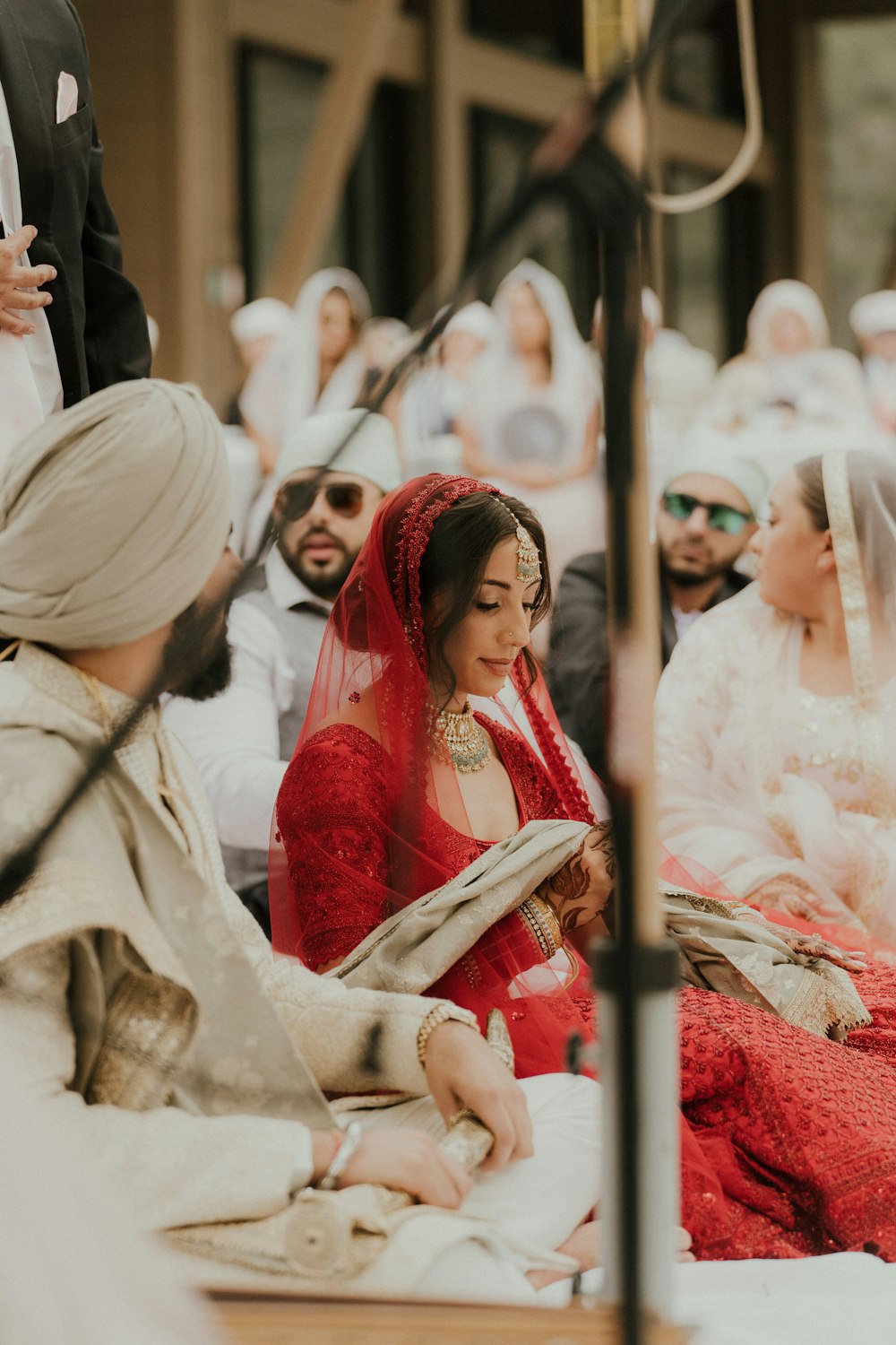 a person in a red dress sitting on a bench with other people