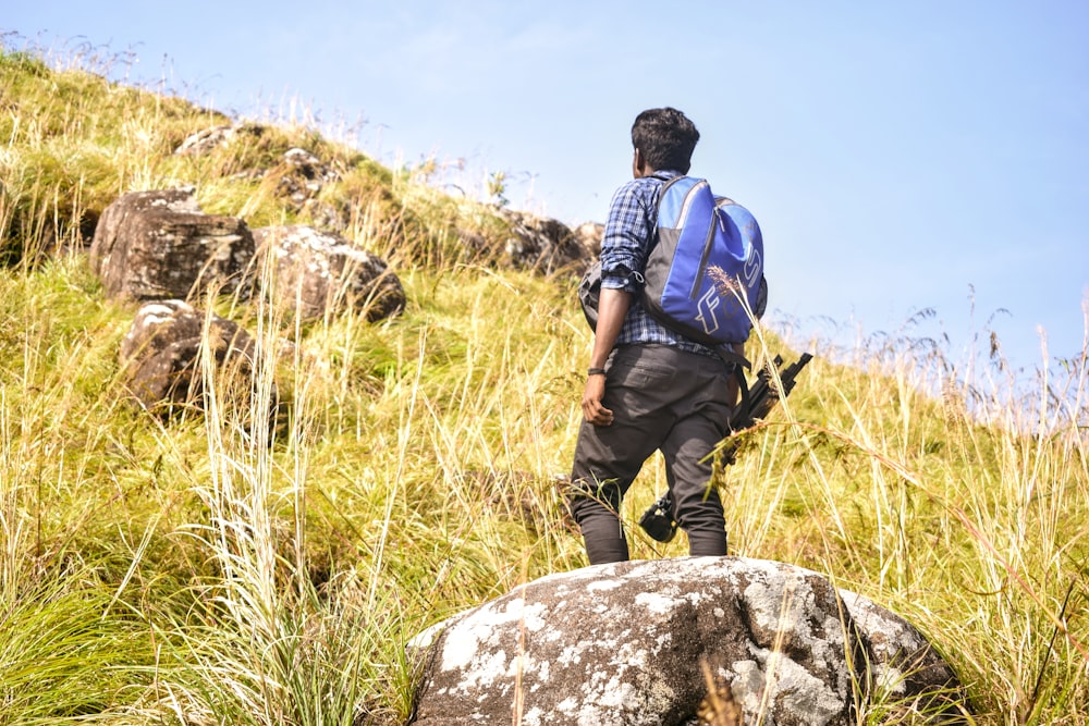 a man with a backpack walking on a rock