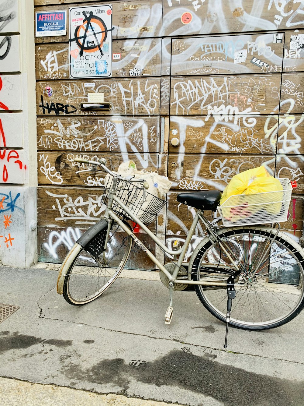 a bicycle parked in front of a wall covered in graffiti