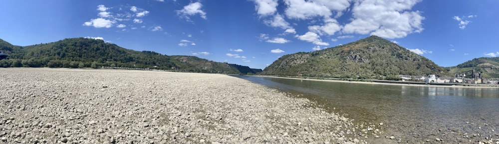 a rocky beach with a hill in the background