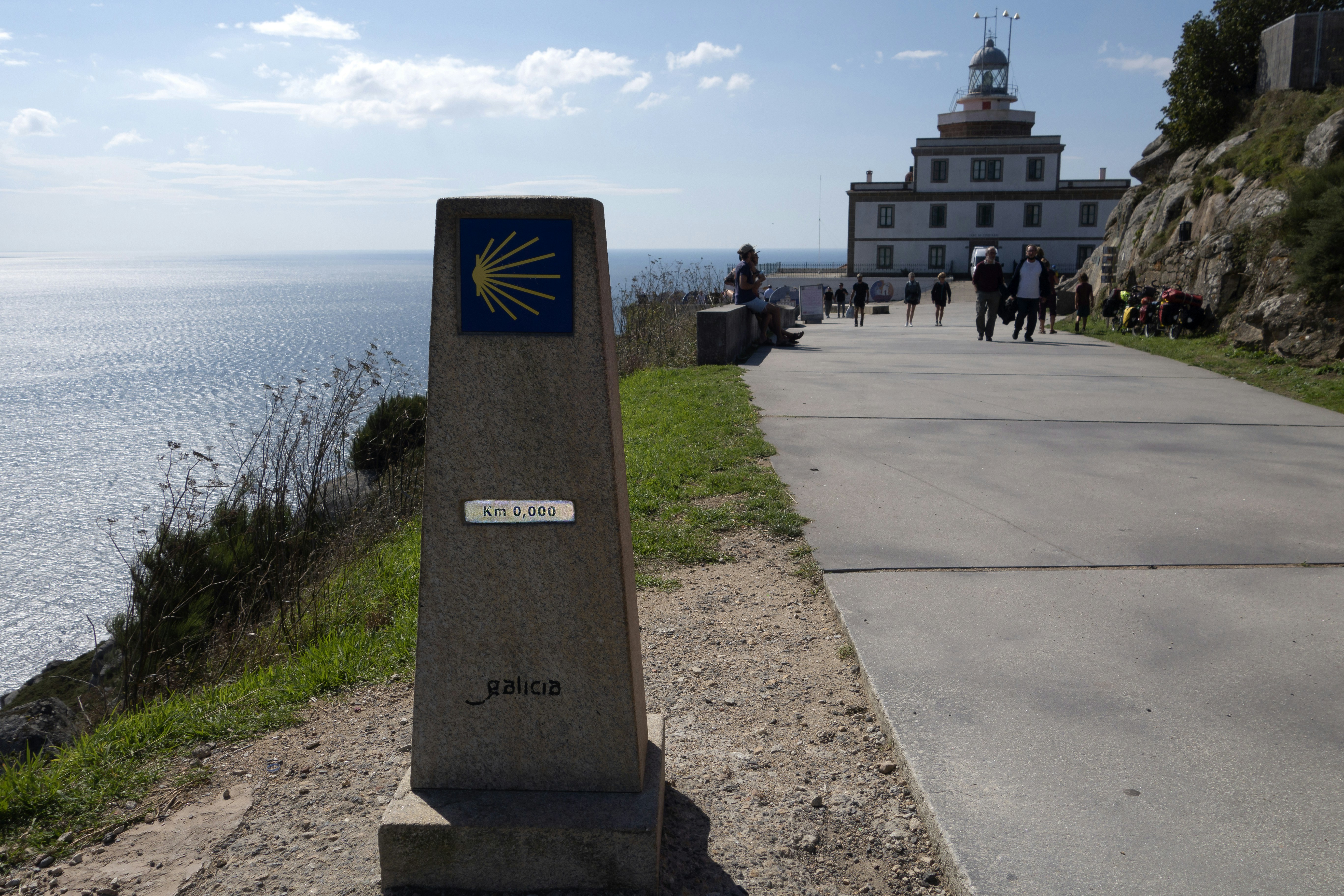 a stone pillar with a sign on it by a body of water