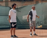 a couple of men stand on a tennis court