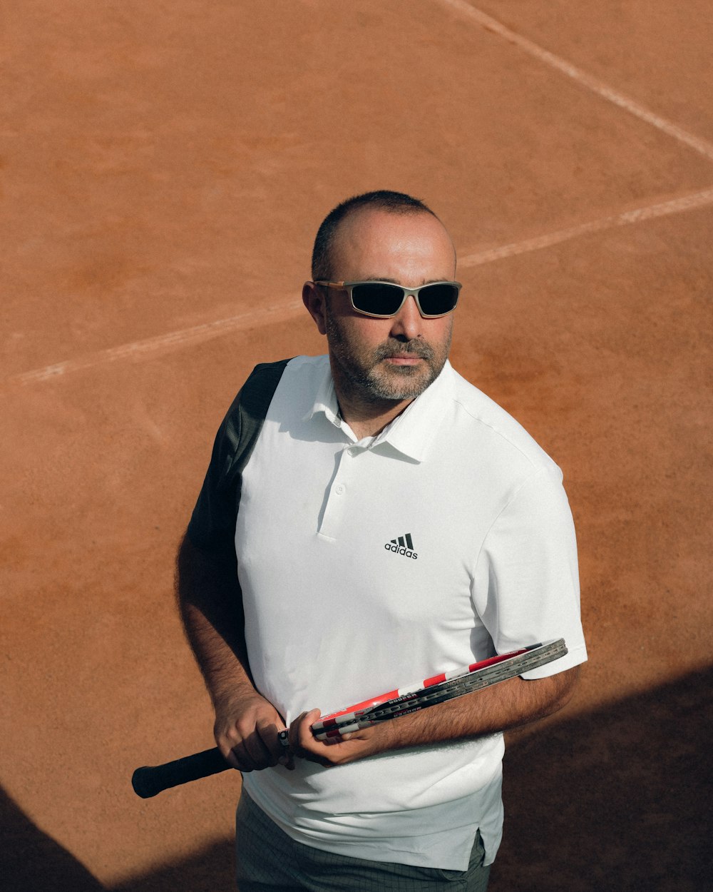 um homem segurando uma raquete de tênis