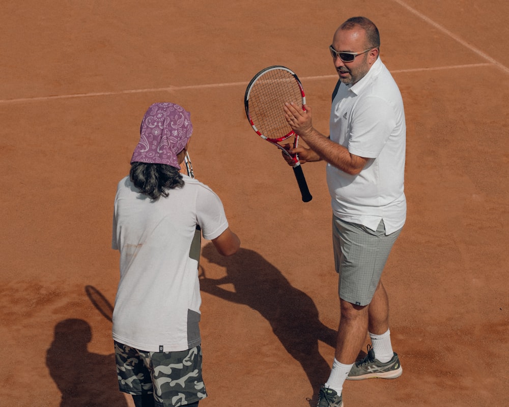 a man and a woman holding tennis rackets