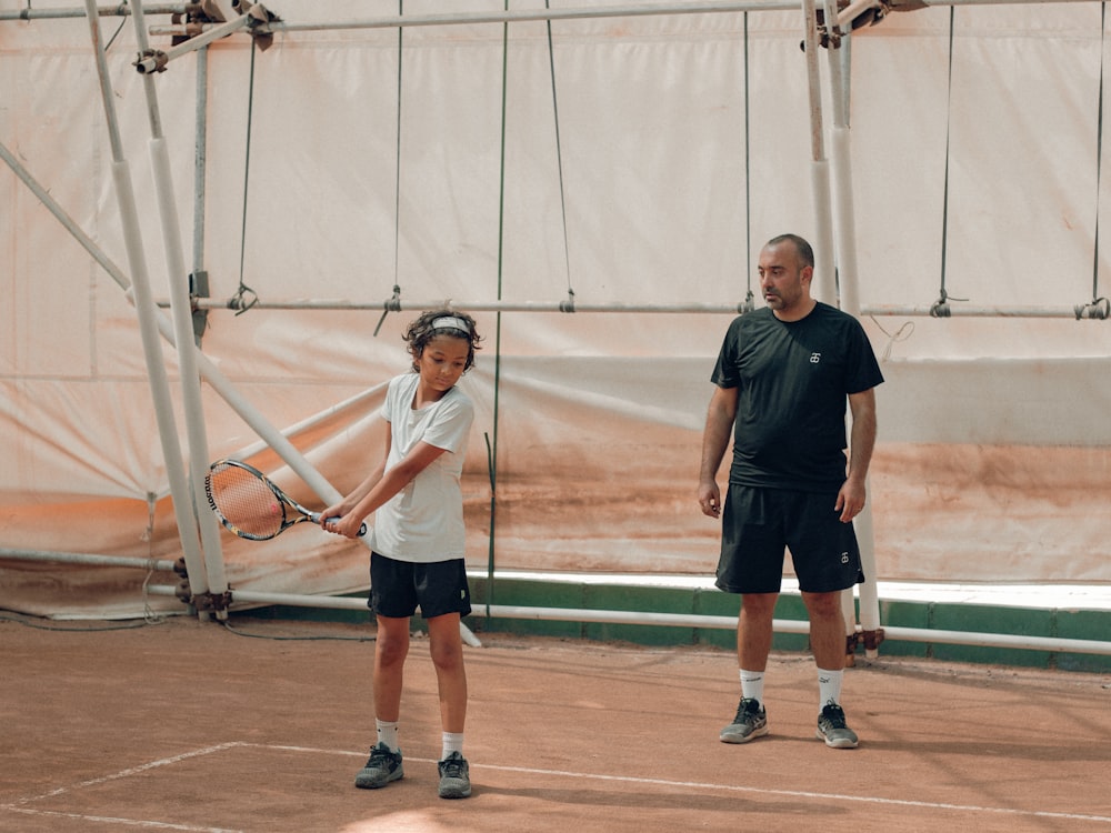 a couple of men stand on a tennis court