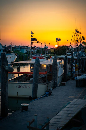 Sunset view of the marina di Scarlino with a boat ready for a private chef experience
