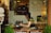 A woman sitting at a cafe, working on her laptop with a coffee beside her.