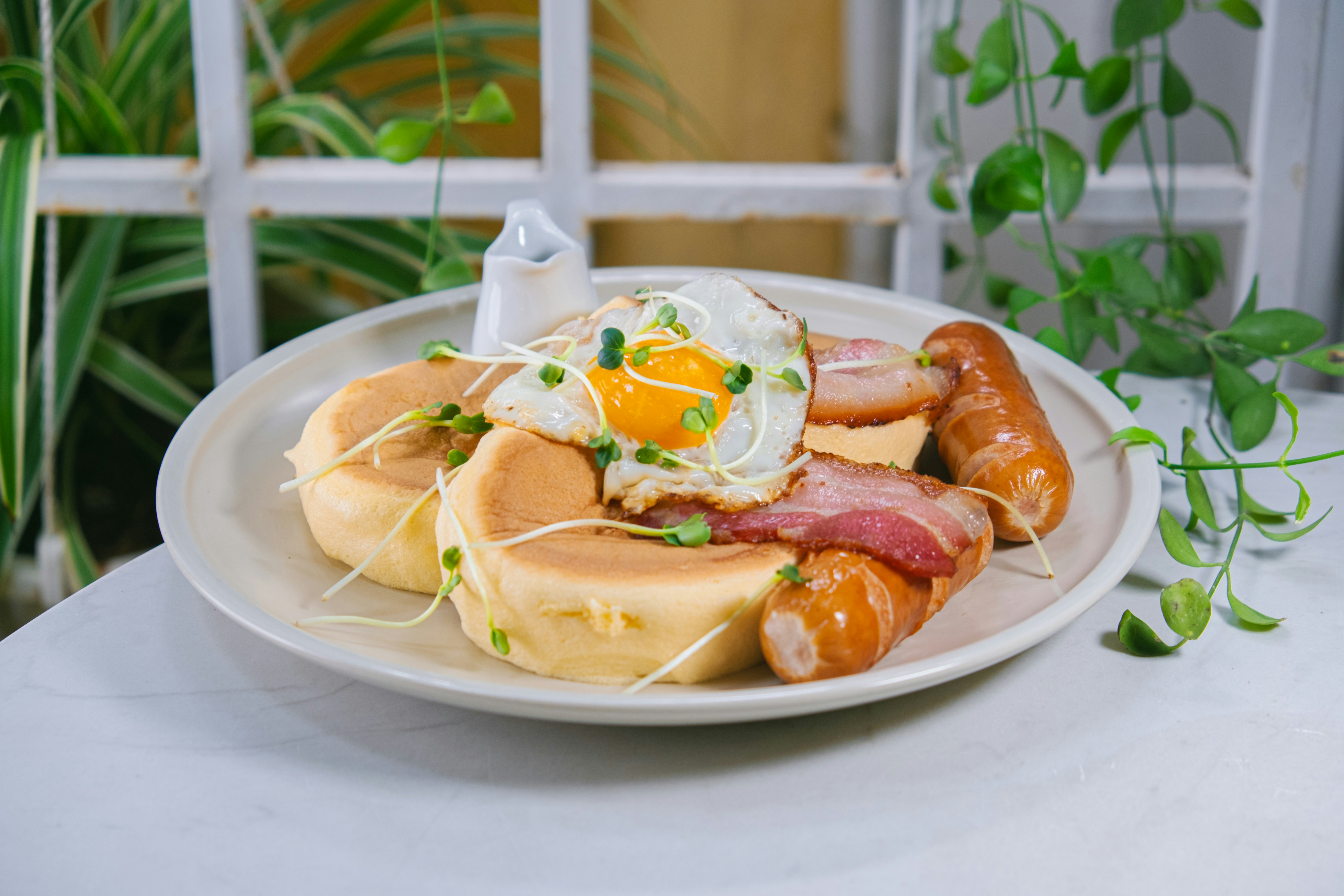 Brunch plate with fried egg, bacon and pancakes