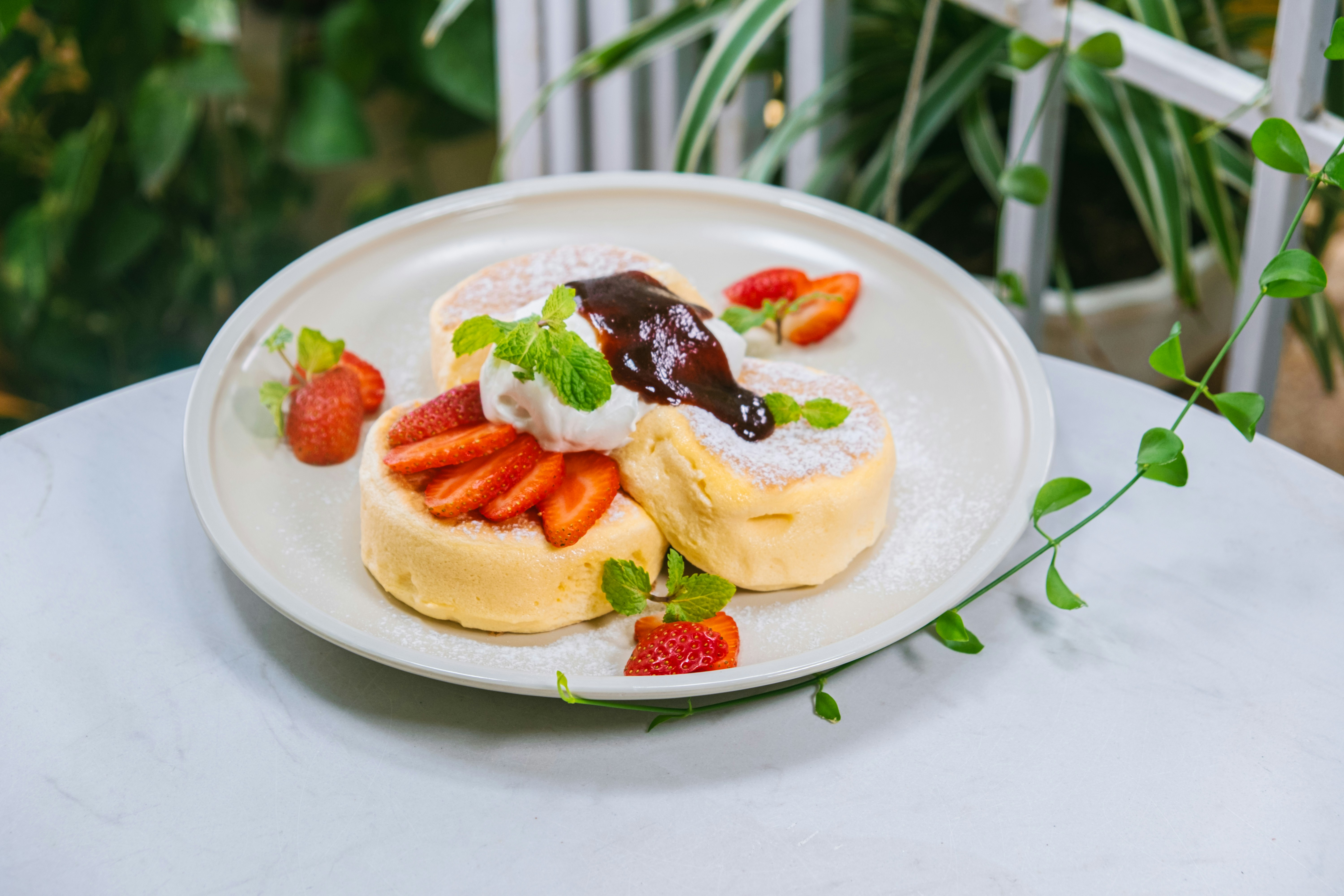 Fluffy pancakes with maple syrup and fresh berries on white plate