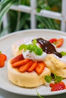 Fluffy pancakes topped with fresh fruits and syrup.