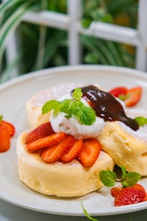 Fluffy pancakes topped with fresh fruits and syrup.