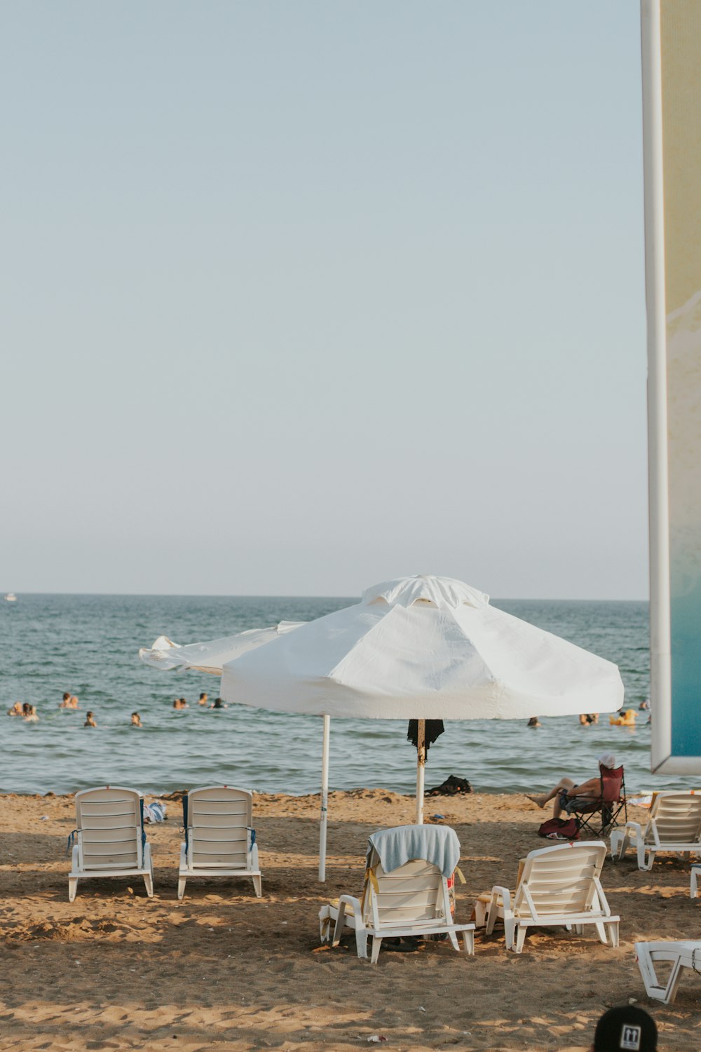 a beach with people and umbrellas