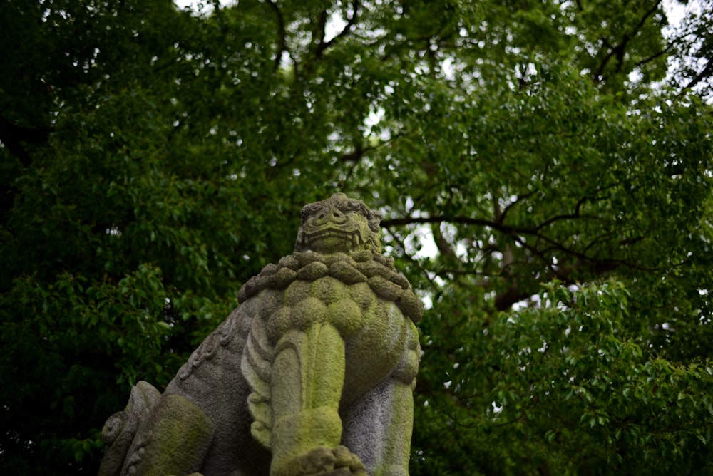 a statue of a person with trees in the background