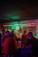 Participants solving a scavenger hunt clue together in front of a neon-lit Spokane bar.