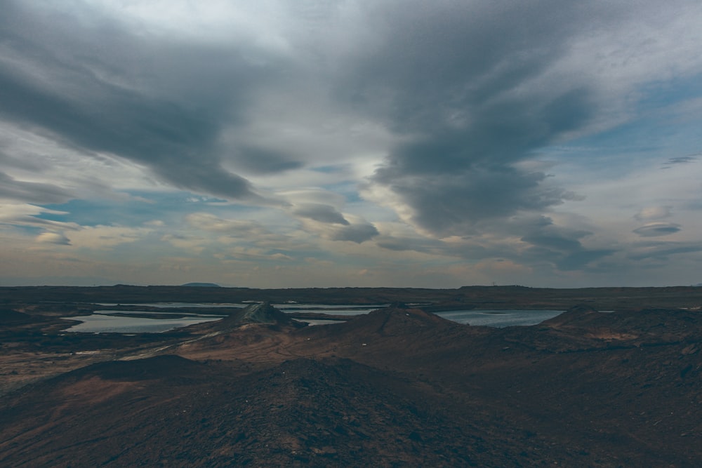 a landscape with hills and a body of water in the distance