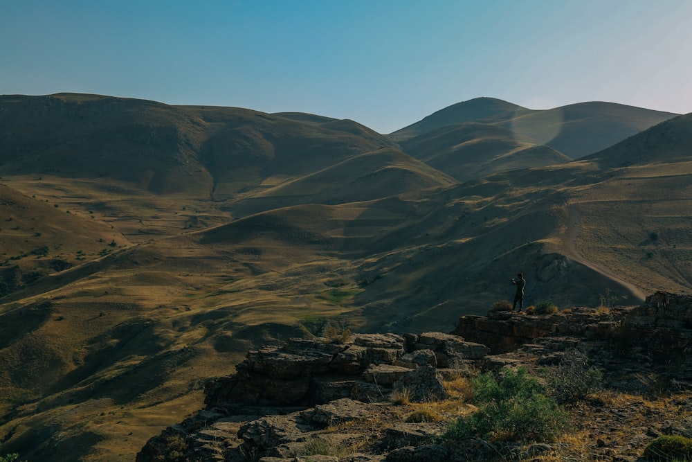 a person standing on a rocky hill