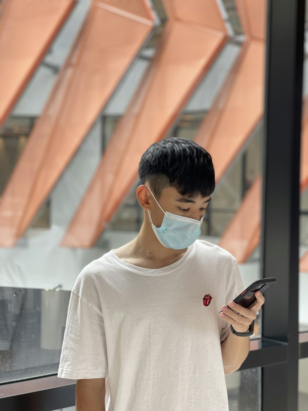 a man wearing a mask looking at a phone