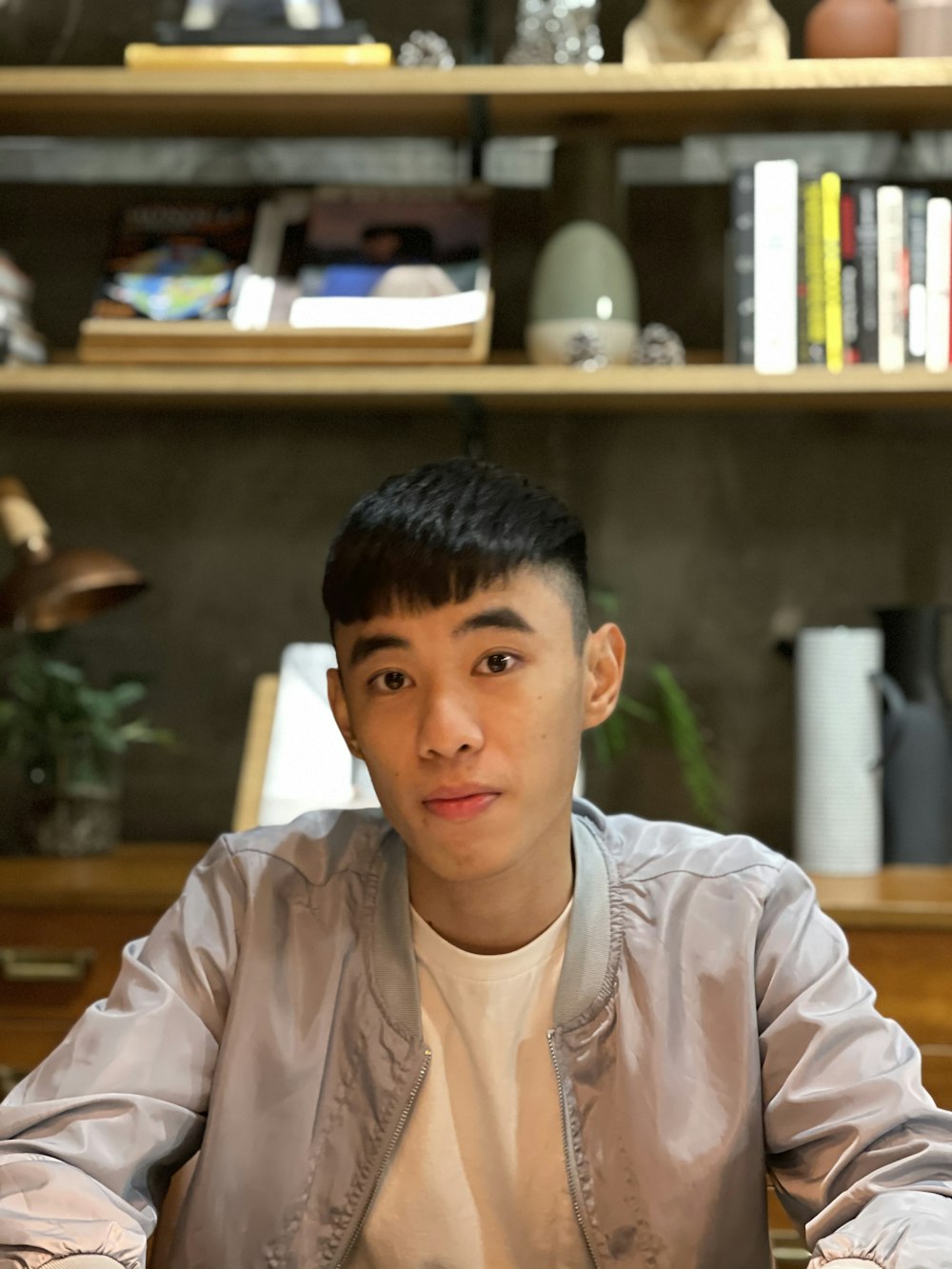 a person sitting in front of a bookshelf