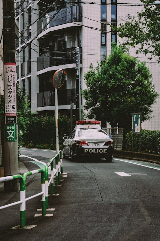 日本街邊停放的警車，車身有 POLICE 字樣