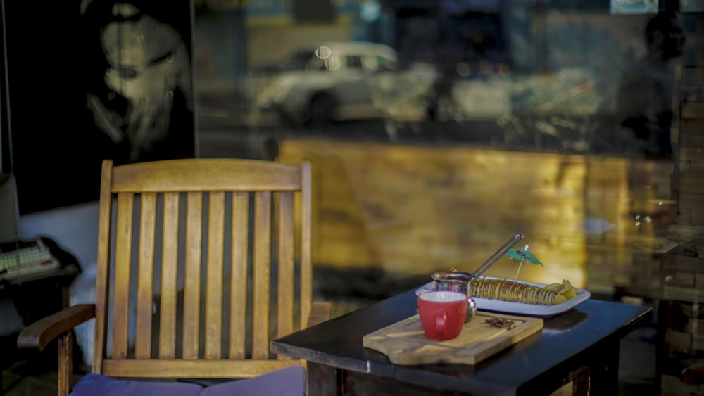 a table with a chair and a window with a view of a street