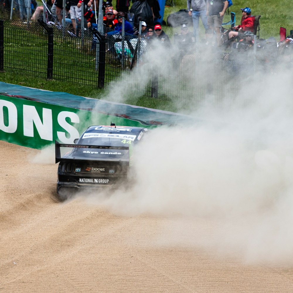 a car driving on a dirt track with smoke coming out of it