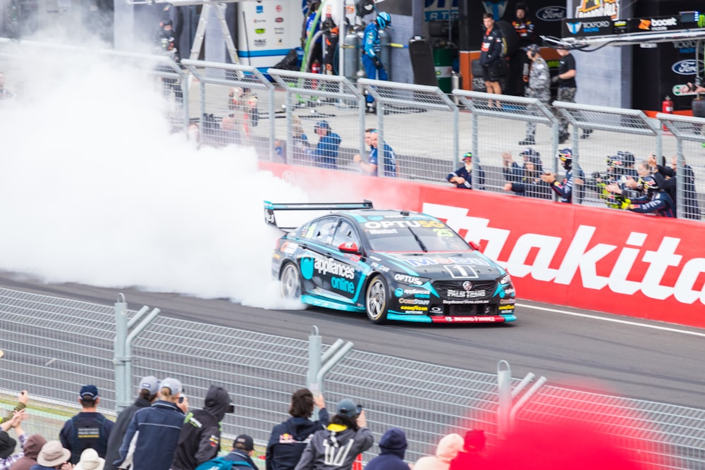 a race car on a track with smoke coming out of it