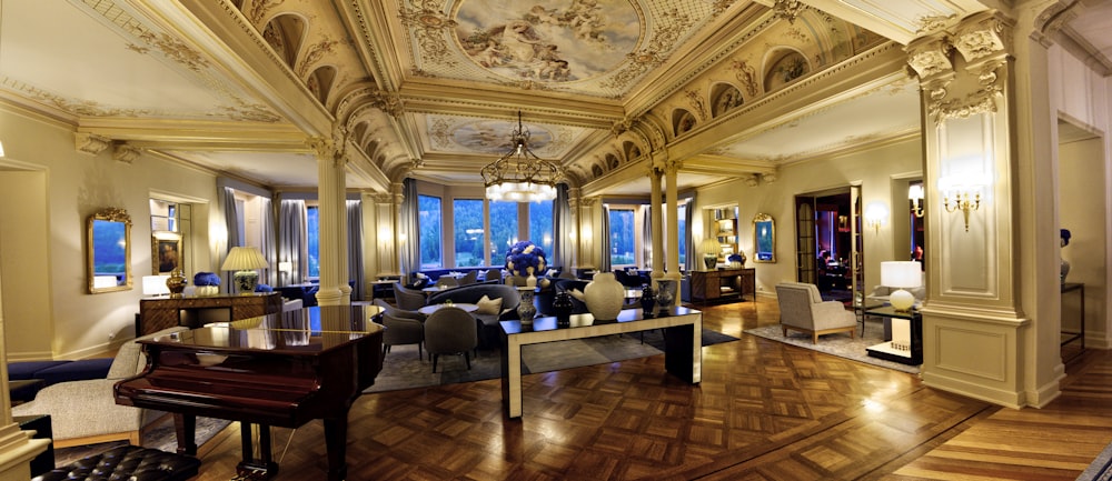 a large room with a piano and chandelier