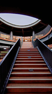 Wide shot of a contemporary interior featuring a metal spiral staircase illuminated by natural light