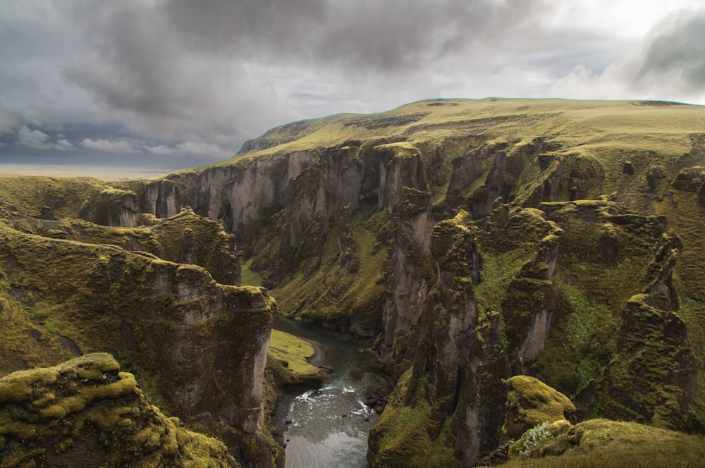 a rocky cliff with a river running through it