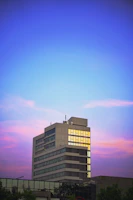 Exterior view of a newly completed corporate building at sunset.