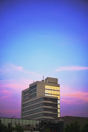 Exterior view of a newly completed corporate building at sunset.