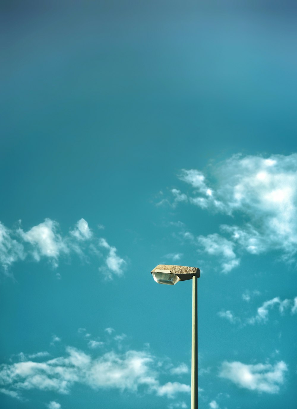 a light post with a blue sky and clouds