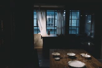 Intimate dining space set for a home-cooked meal with soft ambient lighting.