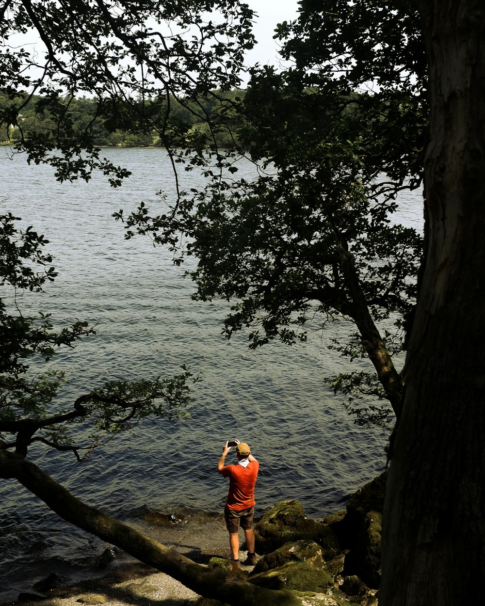 a man taking a picture of a lake