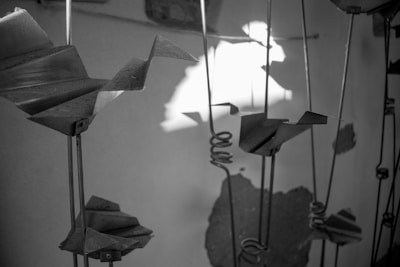 Finished metal sculptures displayed on a rustic wooden table.