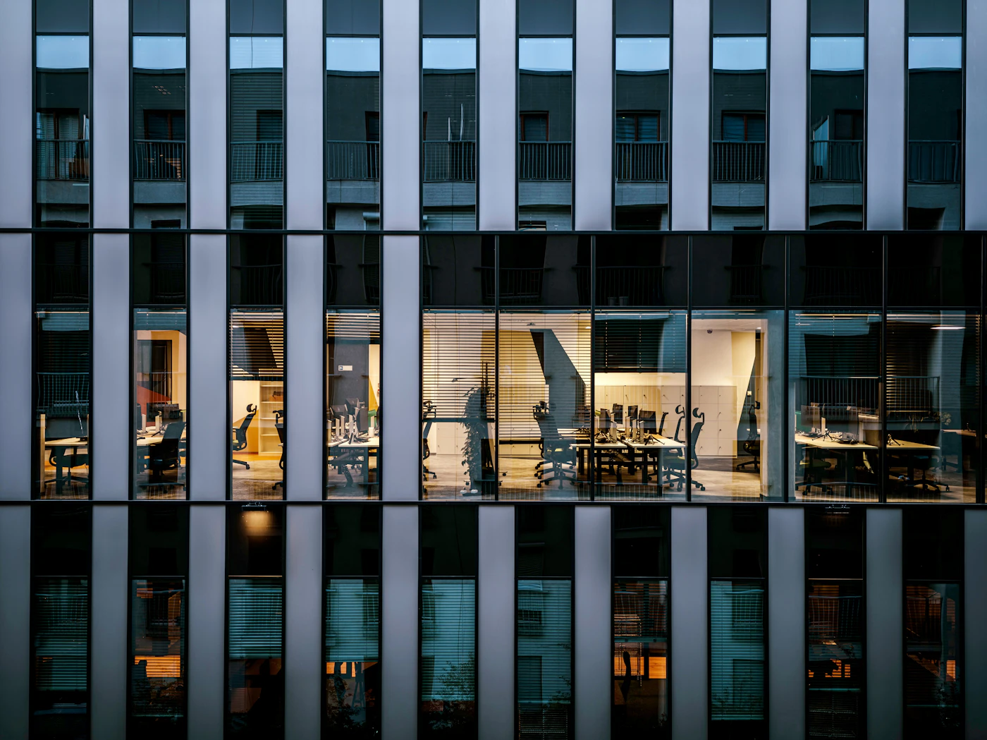 A glass office facade at night with lit windows